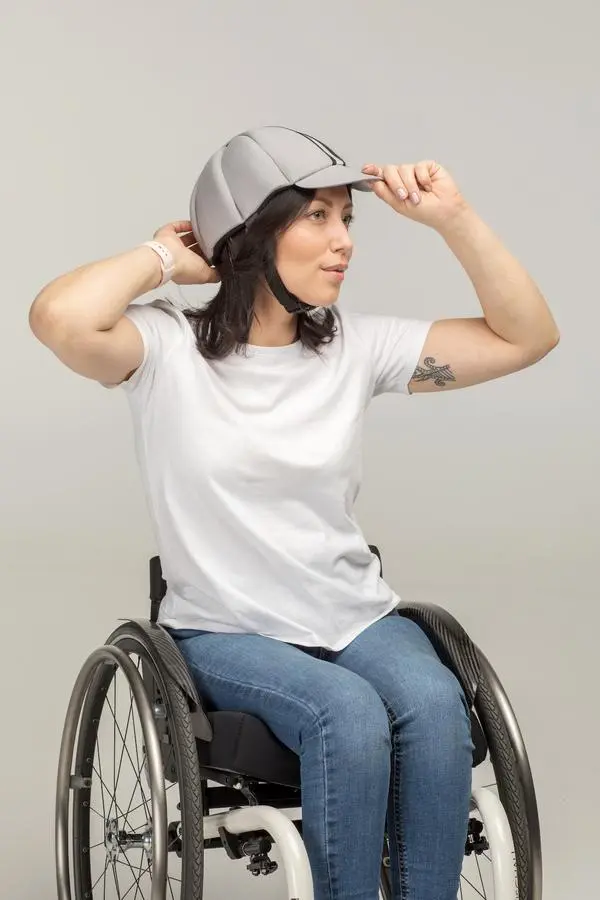 chica en silla de ruedas llevando un casco de protección baseball ribcap asister